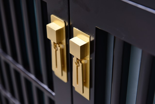 Picture of black cabinets with golden handles.
